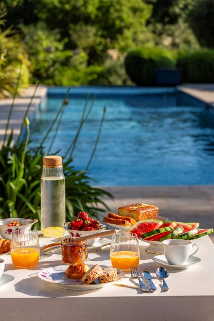 Petit Déjeuner gourmand à Villa Roubia, table extérieure avec le soleil du matin et vue sur la piscine. 