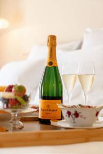Bouteille de Champagne et flûtes servies en chambre à la Villa Roubia
