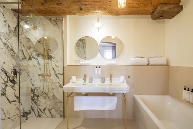 Salle de bain lumineuse dans une suite élégance à Villa Roubia. Poutre apparente, baignoire et douche à l'italienne. 