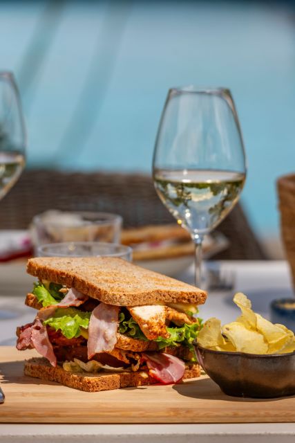 Déjeuner en extérieur d'un club sandwich à Villa Roubia, vue sur la piscine.