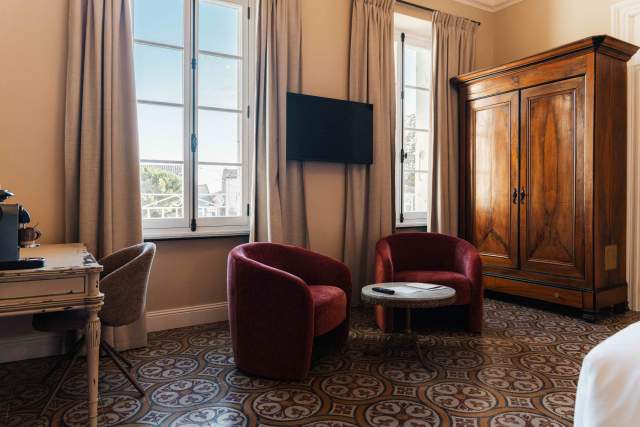 Espace salon avec fauteuils confortables en velours dans une suite junior à villa roubia