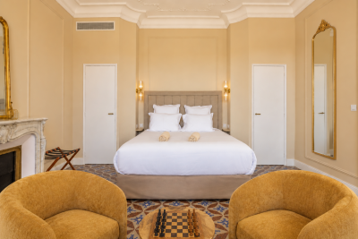 Chambre double lumineuse avec grand lit, ancienne cheminée en marbre et fauteuils - Villa Roubia