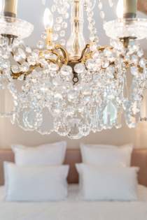 Lustre en cristal doré, symbole du raffinement des chambres de la Villa Roubia