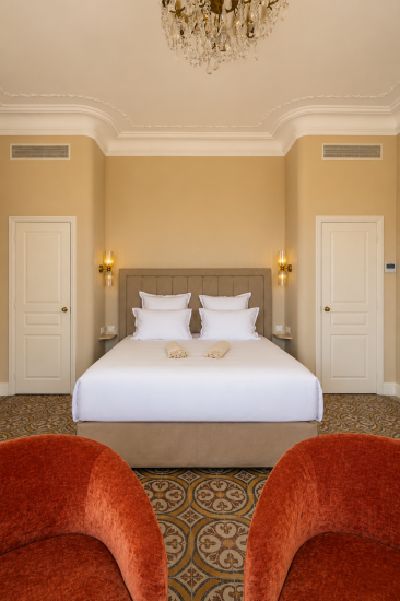 Chambre élégante avec grand lit et carrelage anciens à la Villa Roubia