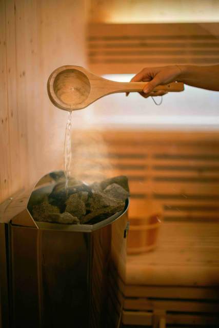 Eau versée sur le four du sauna au spa de villa roubia